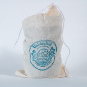 A single canvas drawstring bag with blue Lax Wax cold water logo stands upright against a clean white background, showing the natural fabric texture and minimalist eco-friendly packaging.